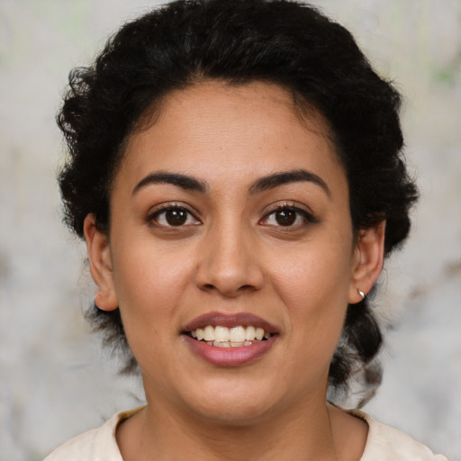 Joyful latino young-adult female with short  black hair and brown eyes