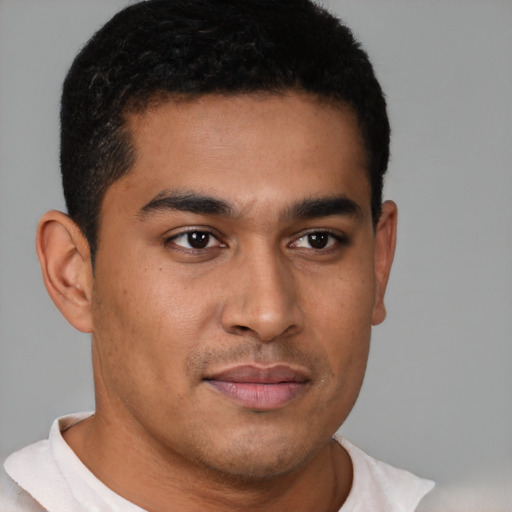 Joyful latino young-adult male with short  brown hair and brown eyes