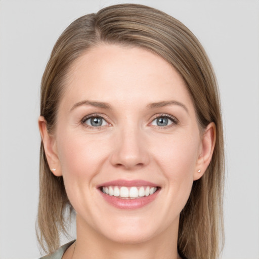 Joyful white young-adult female with medium  brown hair and grey eyes