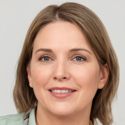 Joyful white adult female with medium  brown hair and grey eyes