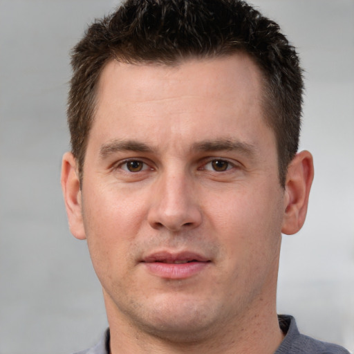 Joyful white young-adult male with short  brown hair and brown eyes