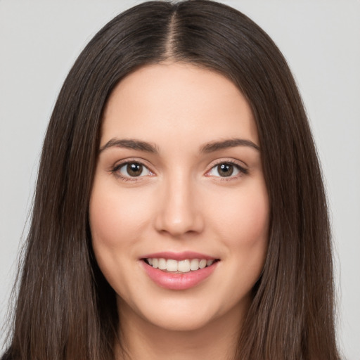 Joyful white young-adult female with long  brown hair and brown eyes