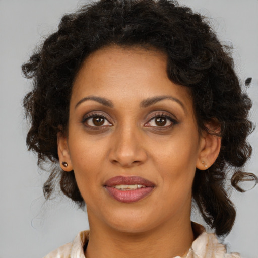 Joyful black young-adult female with medium  brown hair and brown eyes