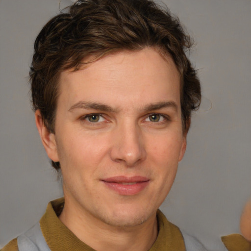 Joyful white young-adult male with short  brown hair and blue eyes