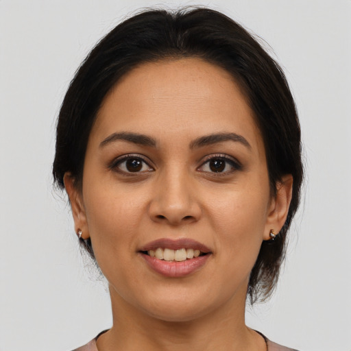 Joyful latino young-adult female with medium  brown hair and brown eyes