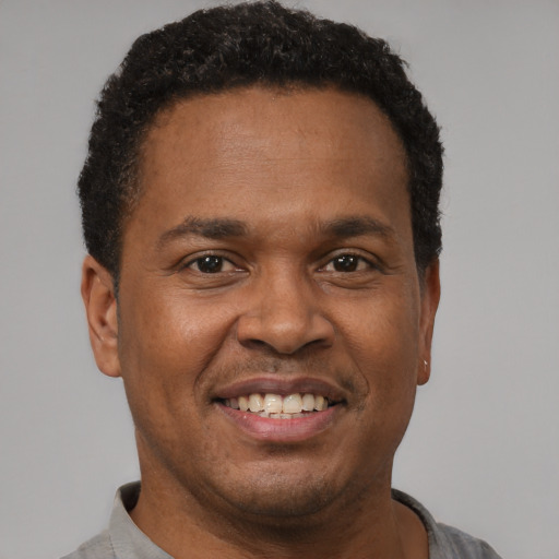 Joyful latino adult male with short  brown hair and brown eyes