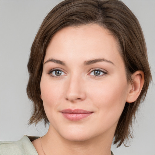 Joyful white young-adult female with medium  brown hair and green eyes