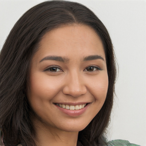 Joyful latino young-adult female with long  brown hair and brown eyes