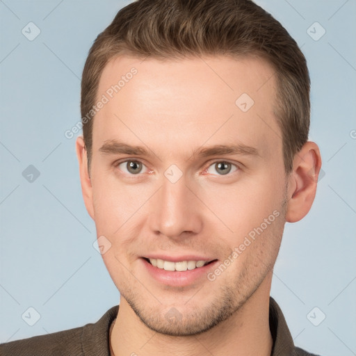 Joyful white young-adult male with short  brown hair and grey eyes