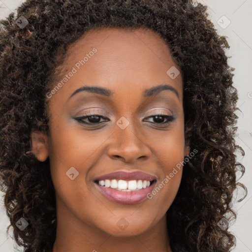 Joyful black young-adult female with long  brown hair and brown eyes