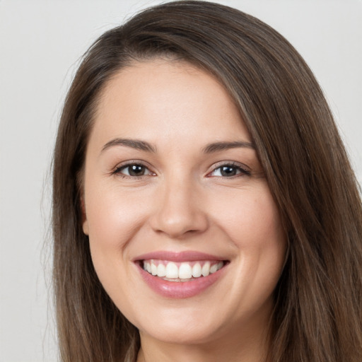 Joyful white young-adult female with long  brown hair and brown eyes