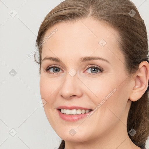 Joyful white young-adult female with long  brown hair and brown eyes