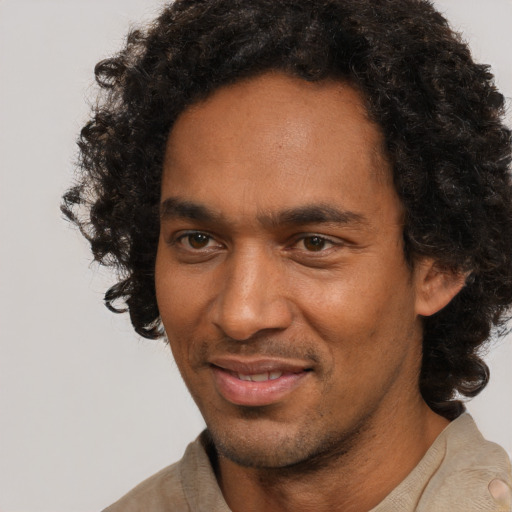 Joyful black adult male with short  black hair and brown eyes