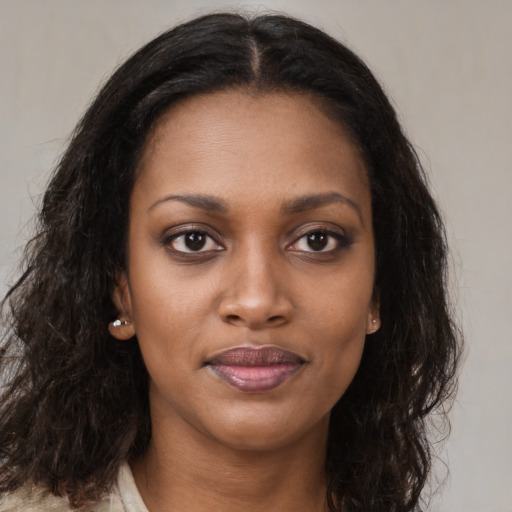 Joyful black young-adult female with long  brown hair and brown eyes