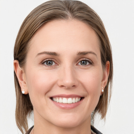 Joyful white young-adult female with medium  brown hair and grey eyes