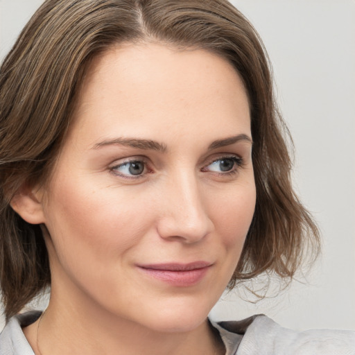 Joyful white young-adult female with medium  brown hair and blue eyes