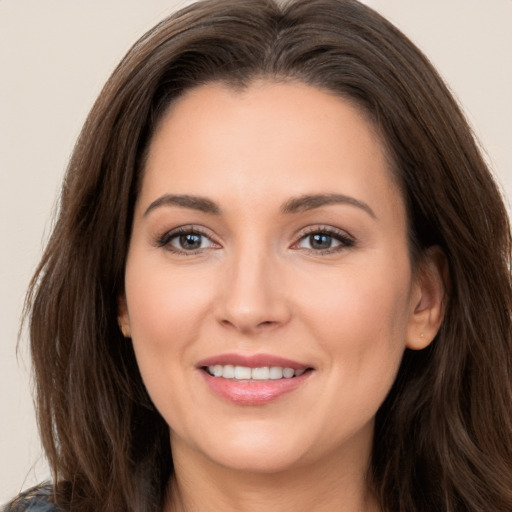 Joyful white young-adult female with long  brown hair and brown eyes