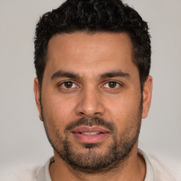 Joyful white young-adult male with short  black hair and brown eyes