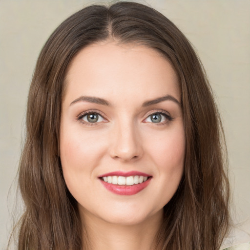 Joyful white young-adult female with long  brown hair and green eyes