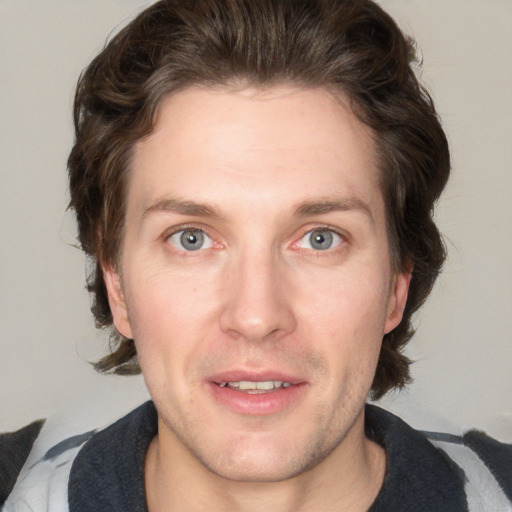 Joyful white adult male with medium  brown hair and blue eyes