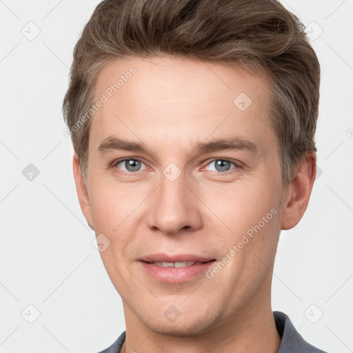 Joyful white young-adult male with short  brown hair and grey eyes