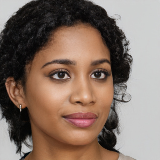 Joyful black young-adult female with medium  brown hair and brown eyes