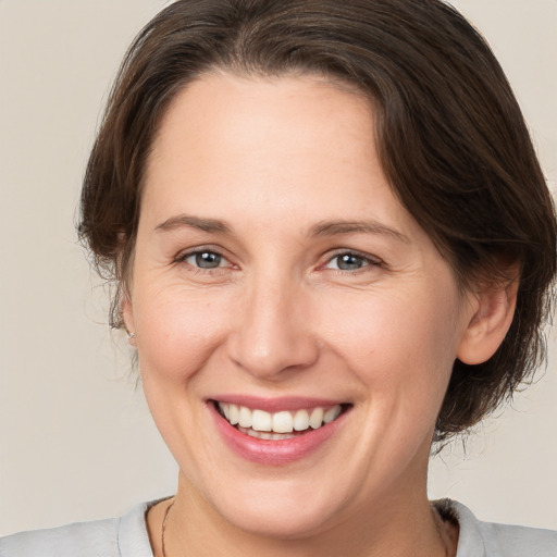 Joyful white adult female with medium  brown hair and brown eyes