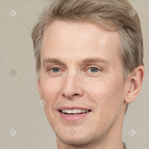 Joyful white adult male with short  brown hair and grey eyes