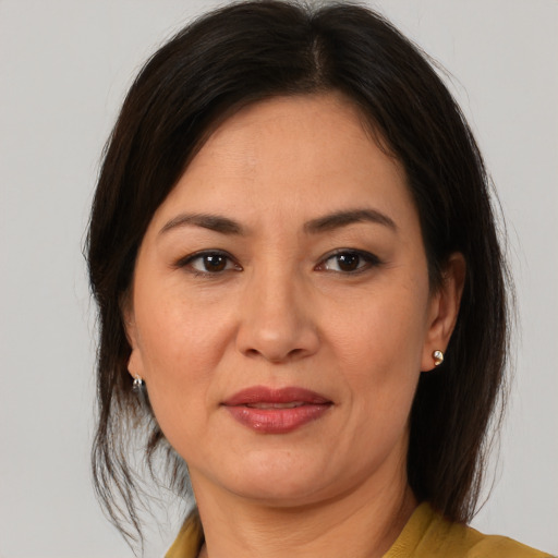 Joyful latino adult female with medium  brown hair and brown eyes