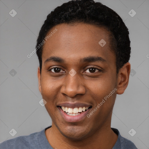 Joyful black young-adult male with short  brown hair and brown eyes