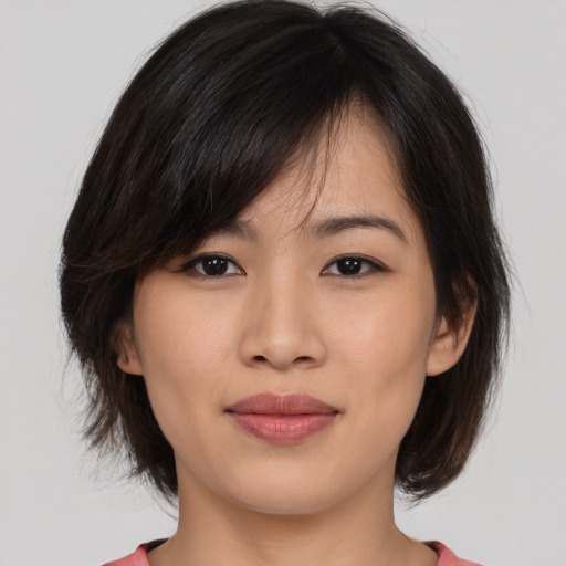 Joyful asian young-adult female with medium  brown hair and brown eyes