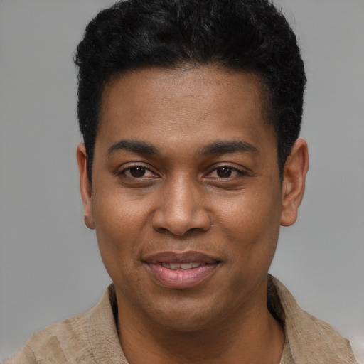 Joyful black young-adult male with short  black hair and brown eyes