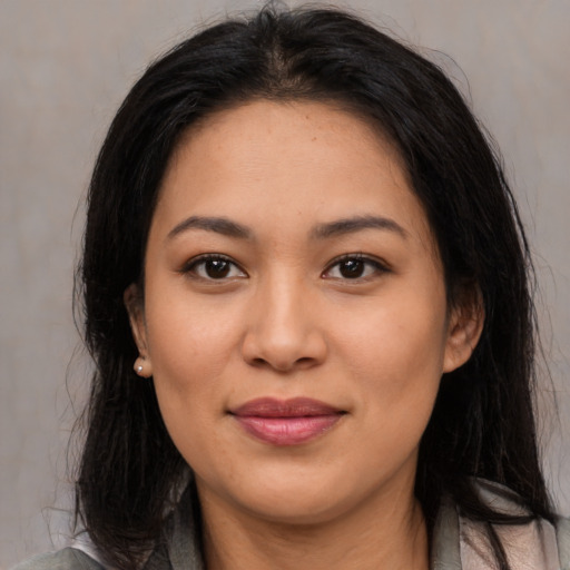 Joyful latino young-adult female with long  brown hair and brown eyes