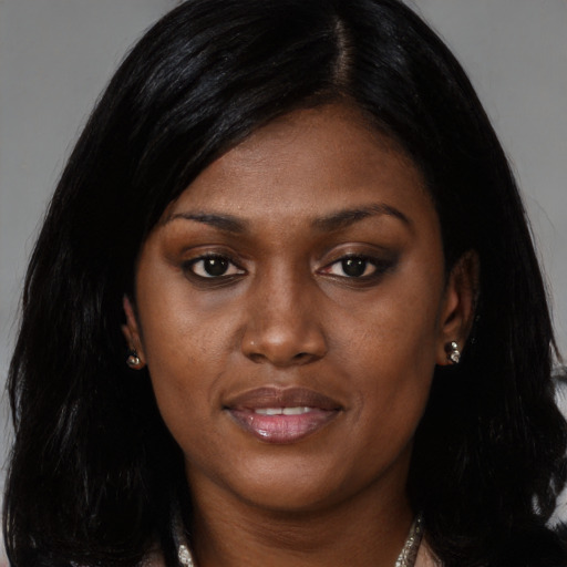 Joyful black young-adult female with long  black hair and brown eyes