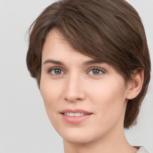 Joyful white young-adult female with medium  brown hair and grey eyes