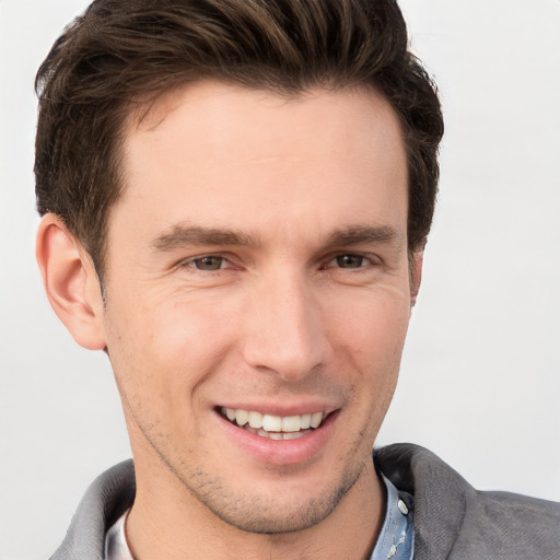 Joyful white young-adult male with short  brown hair and grey eyes