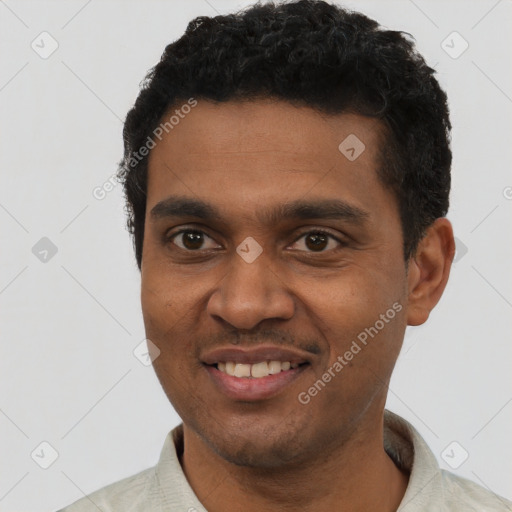 Joyful black young-adult male with short  black hair and brown eyes