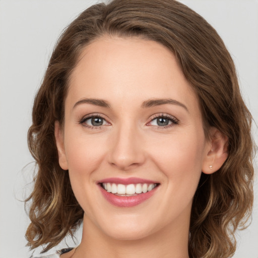 Joyful white young-adult female with medium  brown hair and green eyes