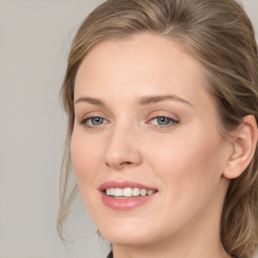 Joyful white young-adult female with medium  brown hair and blue eyes