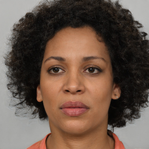 Joyful black young-adult female with medium  brown hair and brown eyes