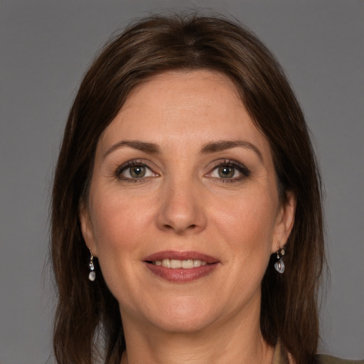 Joyful white adult female with long  brown hair and grey eyes