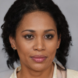 Joyful latino adult female with medium  brown hair and brown eyes