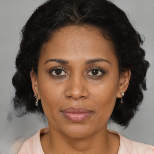 Joyful latino adult female with medium  brown hair and brown eyes