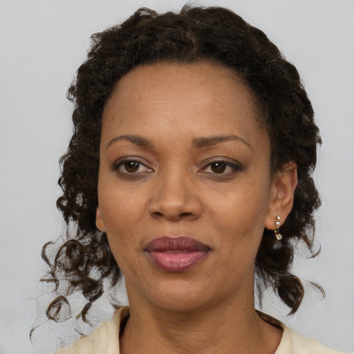 Joyful black adult female with medium  brown hair and brown eyes