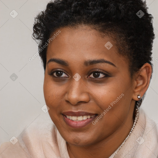 Joyful black young-adult female with short  brown hair and brown eyes