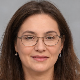 Joyful white adult female with long  brown hair and grey eyes