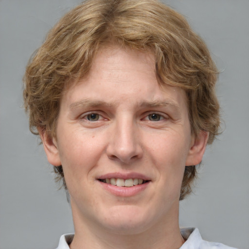 Joyful white young-adult male with medium  brown hair and grey eyes