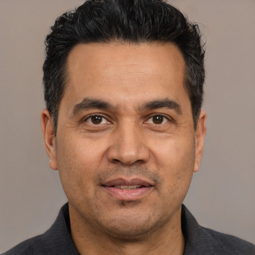 Joyful white adult male with short  black hair and brown eyes