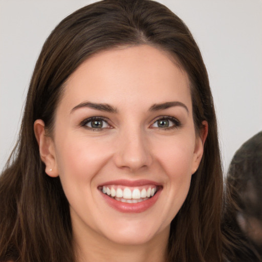 Joyful white young-adult female with long  brown hair and brown eyes