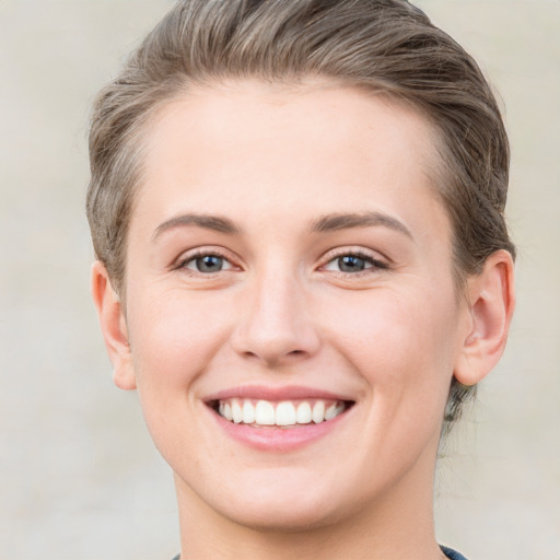 Joyful white young-adult female with short  brown hair and grey eyes